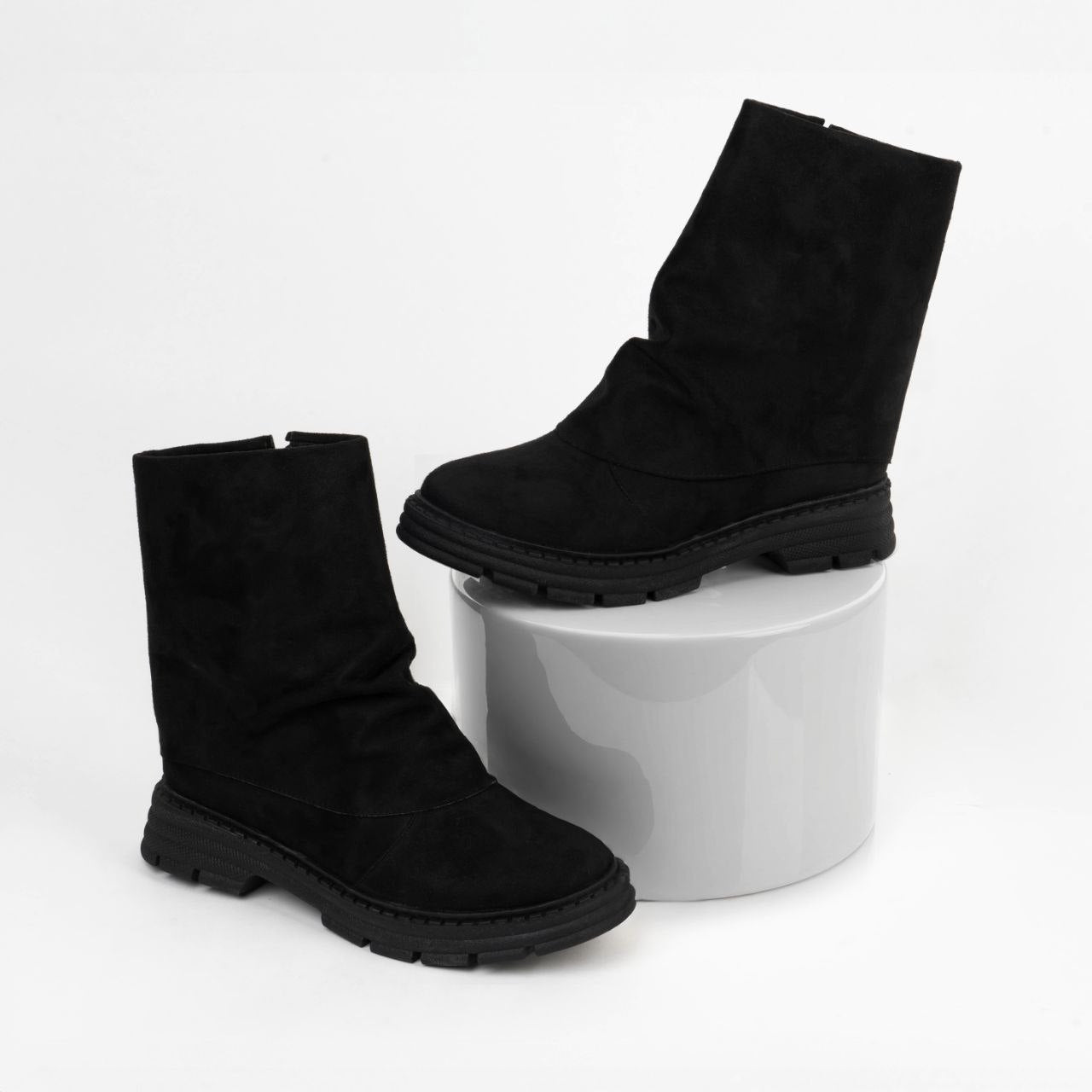 Black suede slouchy boots with a thick chunky lug sole and side zipper.